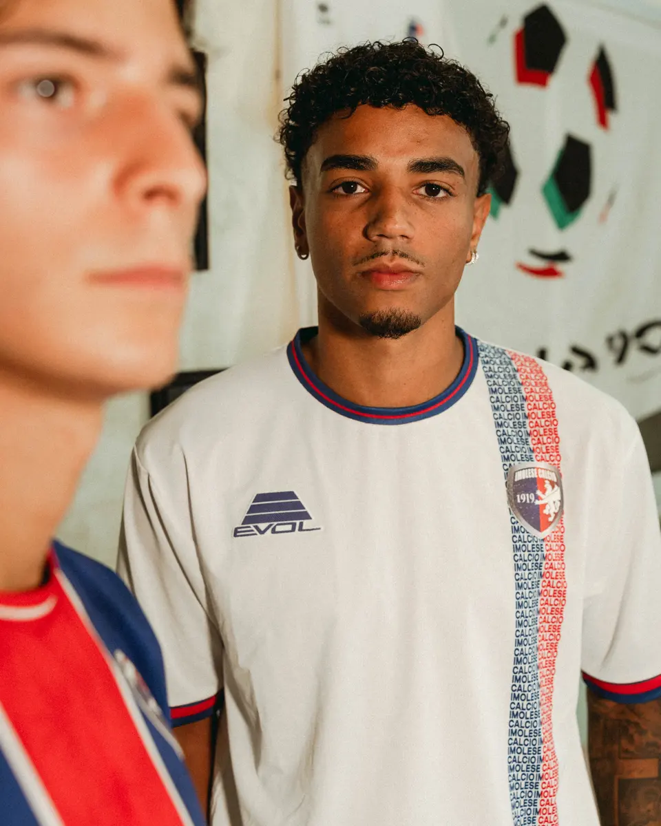 La maglia bianca 2026/27 indossata: stemma, logo Evol e fascia verticale con le scritte rossoblù