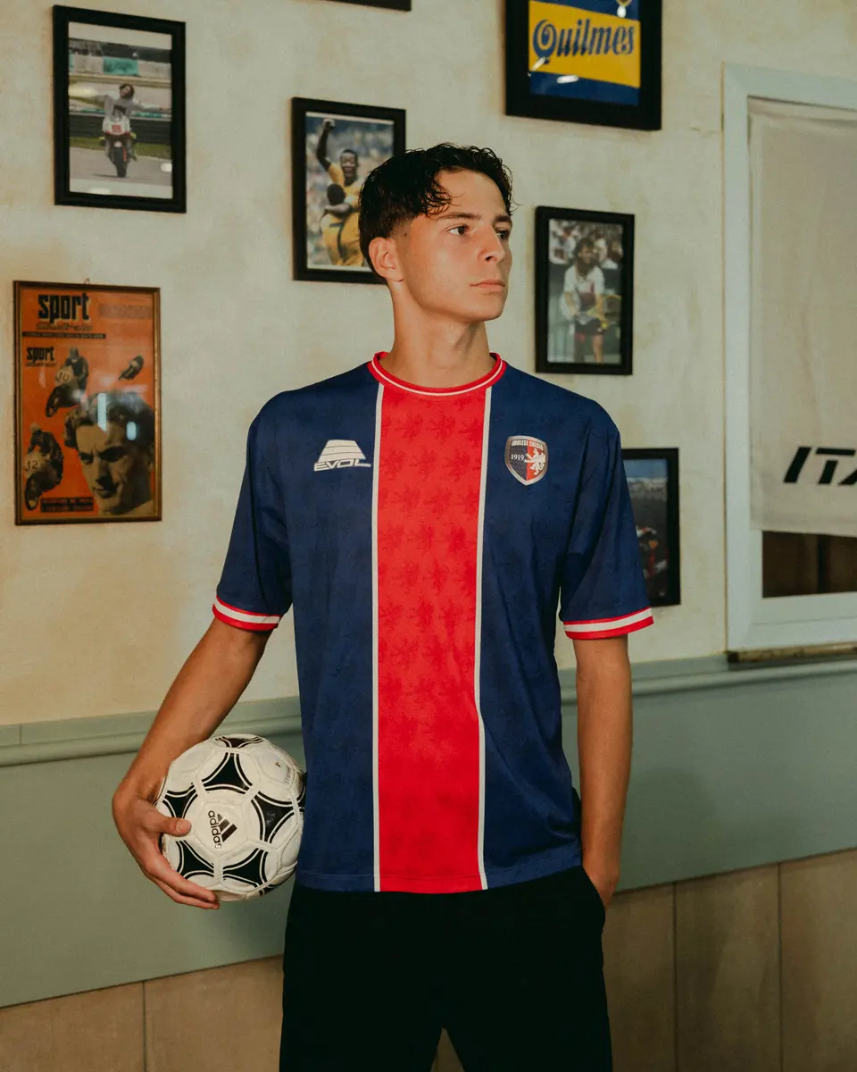 Un ragazzo con la maglia blu e rossa 2026/27 dell’Imolese tiene un pallone sotto il braccio