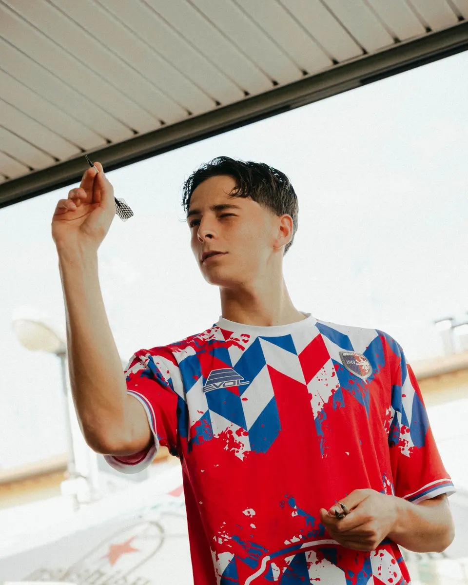 Un ragazzo con la maglia rossa 2026/27 dell’Imolese lancia una freccetta